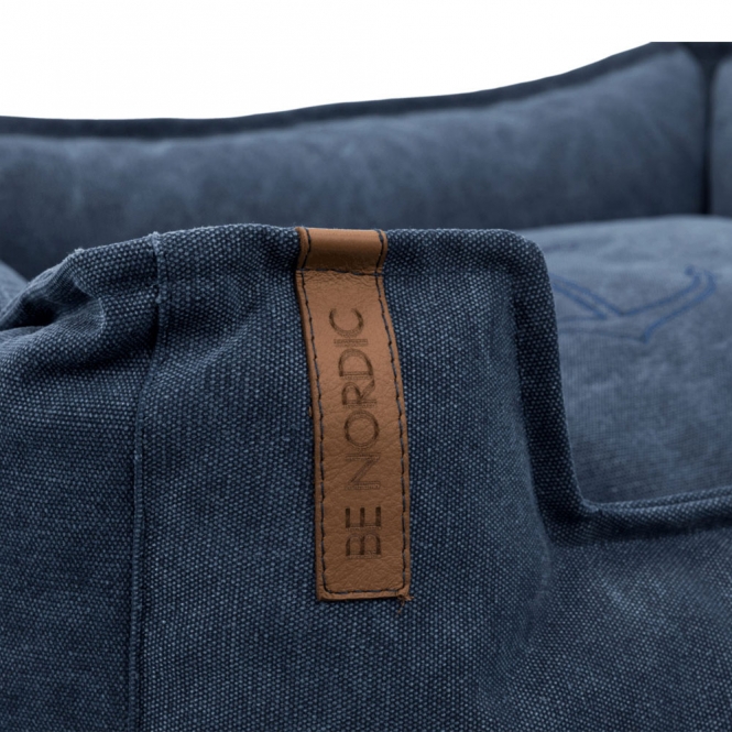 Entdecken Sie die perfekte Kombination aus Komfort und Stil mit unserem hochwertigen Hundebett in Dunkelblau. Der Bezug aus robustem Baumwoll-/Polyester-Material sorgt für eine angenehme Canvas-Haptik und ist besonders langlebig. Die Schaumstoffflocken-Füllung bietet optimalen Liegekomfort, während das fest integrierte Kissen zusätzlichen Halt bietet. Dank des abnehmbaren Bezugs, der bei 40°C waschbar ist, bleibt das Bett stets frisch und sauber. Der rutschfeste Boden sorgt dafür, dass das Hundebett an seinem Platz bleibt, egal wie wild es zugeht. Mit praktischen Tragegriffen ist es zudem einfach zu transportieren. Hergestellt in der EU, unterstützt der Verkauf dieses Produkts auch Meeresschutzprojekte und trägt somit aktiv zum Natur- und Artenschutz bei. Gönnen Sie Ihrem vierbeinigen Freund den besten Schlafplatz mit unserem robusten und stilvollen Hundebett in der Größe 100 x 80 cm!