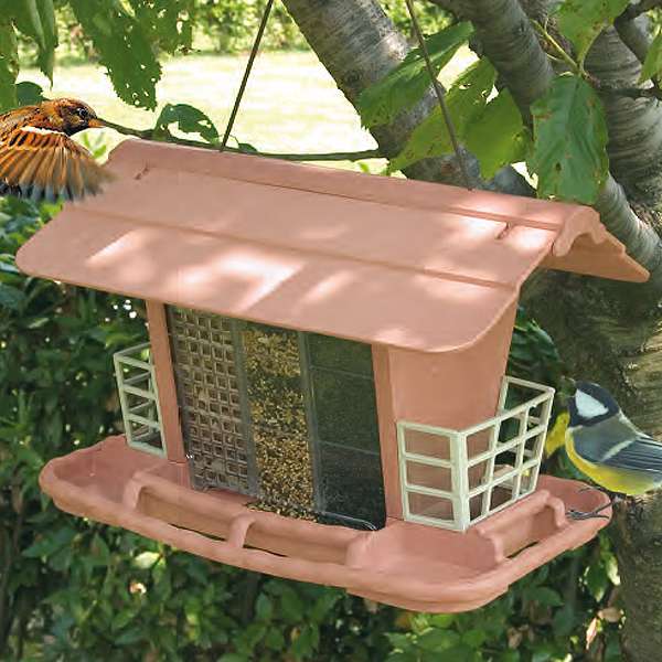 Dieses formschöne Futterhaus aus stabilem, wetterfestem Kunststoff ist perfekt für Wild- und Volierenvögel. Mit drei praktischen Fächern ermöglicht es die Fütterung mit verschiedenen Samen und Nüssen, während die Körbchen an den Giebelseiten ideal sind, um frisches Obst anzubieten. Im Sommer können die Unterteilungen entfernt werden, sodass ein vielseitiges Vogelhaus entsteht, in dem auch Gemüse oder Obst angeboten werden kann. Die einfache Befüllung erfolgt über das aufklappbare Dach, und die Sitzstangen rundherum bieten den Vögeln einen bequemen Platz zum Fressen von beiden Seiten. Der Bausatz lässt sich unkompliziert zusammenstecken, was die Montage zum Kinderspiel macht. Mit kompakten Maßen von ca. 34 x 26 x 23 cm ist dieses Futterhaus eine hochwertige und günstige Lösung für jeden Vogelliebhaber, der seinen gefiederten Freunden eine sichere und ansprechende Futterstelle bieten möchte.